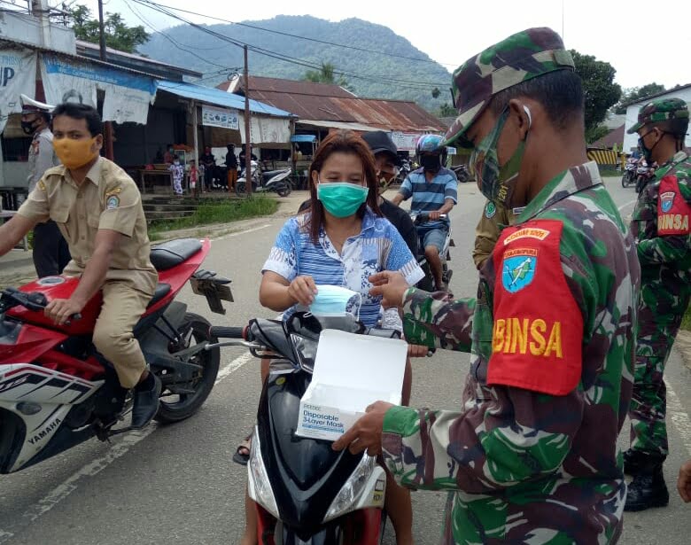 Cegah Covid-19, Babinsa Bagikan Masker di Pasar Pahauman