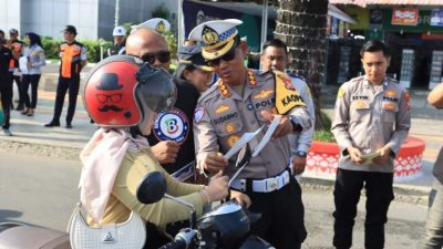 Petugas Ditlantas Polda Bengkulu membagikan stiker keselamatan berkendara kepada pengendara di Simpang Lima Kota Bengkulu