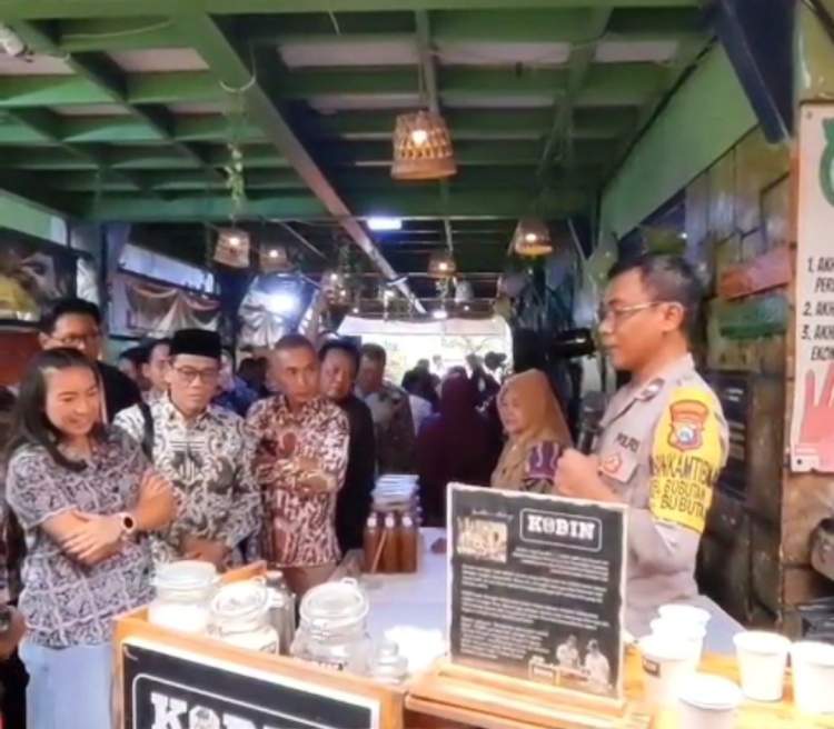 Bhabinkamtibmas Polda Jatim Sugeng Bin Wahab membagikan kopi gratis kepada warga saat sambang desa dalam program Kobin.