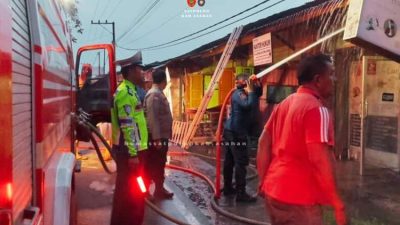 Petugas Damkar Asahan memadamkan kebakaran lima toko di Pulau Rakyat Pekan