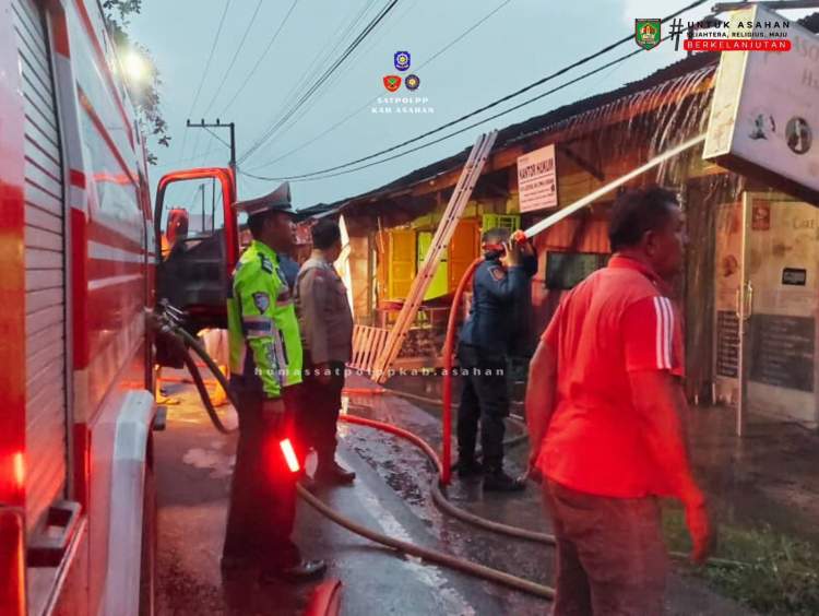 Petugas Damkar Asahan memadamkan kebakaran lima toko di Pulau Rakyat Pekan