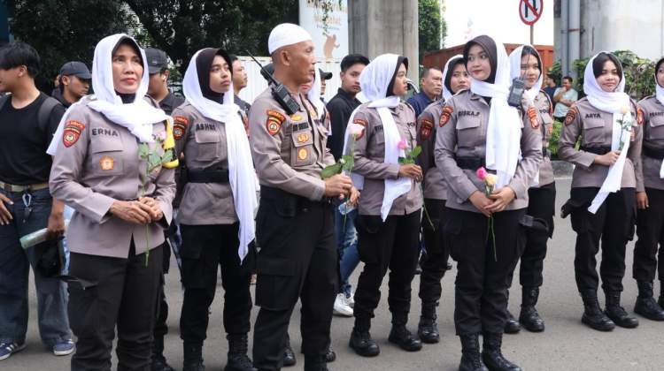 Personel Polda Metro Jaya mengenakan peci dan jilbab saat mengamankan aksi mahasiswa di depan Mabes Polri pada bulan Ramadhan.