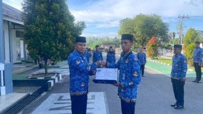 Plt Kepala Rutan Ambon Jefry Persulessy menyerahkan penghargaan pegawai teladan kepada Faisal Ridi di Rutan Kelas IIA Ambon