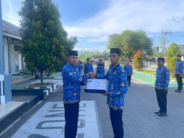 Plt Kepala Rutan Ambon Jefry Persulessy menyerahkan penghargaan pegawai teladan kepada Faisal Ridi di Rutan Kelas IIA Ambon