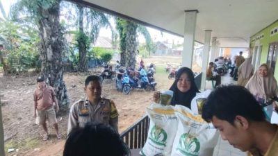 Petugas Polsek Seginim mengawal penyaluran bantuan pangan kepada warga di Desa Banding Agung