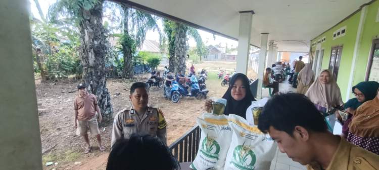 Petugas Polsek Seginim mengawal penyaluran bantuan pangan kepada warga di Desa Banding Agung
