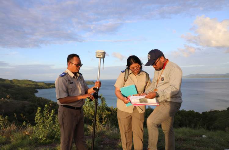 Petugas resmi BPN sedang mengukur tanah dengan dokumen dan identitas lengkap