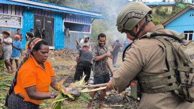 personel Satgas Damai Cartenz mengikuti tradisi bakar batu bersama warga di Sugapa Intan Jaya Papua dalam suasana kebersamaan