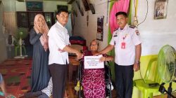 Petugas desa memberikan bantuan BLT Dana Desa kepada seorang lansia di dalam rumah.