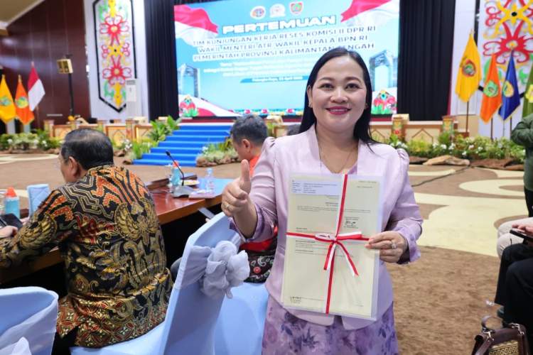 Pendeta Ina Gantiani menerima sertipikat tanah Gereja GKE Bethesda Bumi Palangka dalam acara penyerahan sertipikat di Palangkaraya.