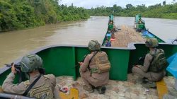 Personel Satgas Ops Damai Cartenz bersama Polres Yahukimo mengawal kapal logistik BBM dan sembako di jalur perairan menuju Dekai, Yahukimo.